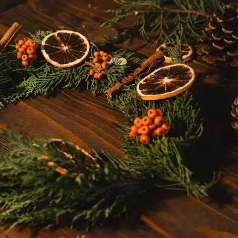 De acht jaarfeesten vieren als heks. Heksenrad voor Yule, krans van dennentakken, bessen en sinaasappel